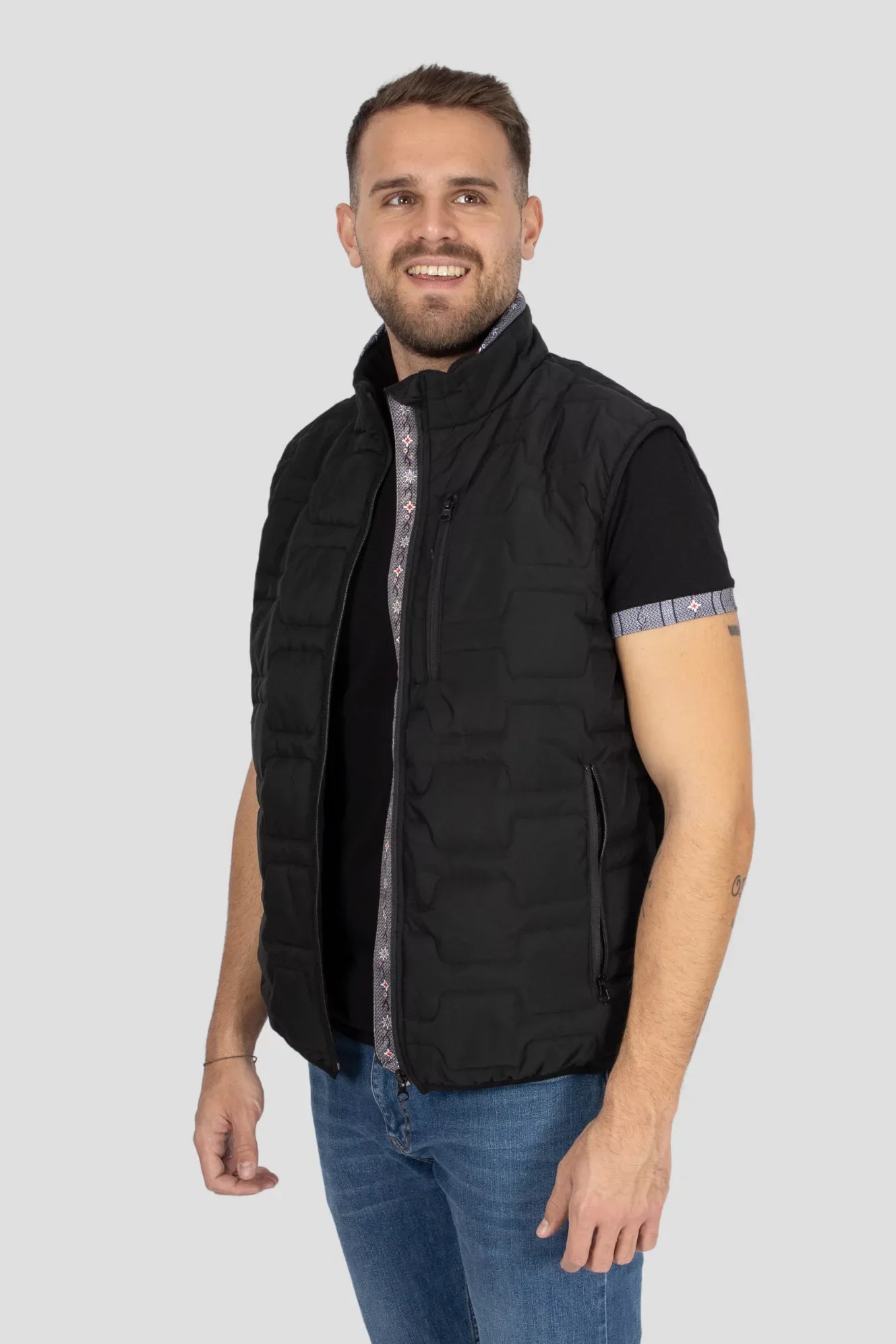 Gilet Edelweiss Herren in Schwarz mit grauem Edelweiss-Muster, hochwertig verarbeitet, mit dezenten Edelweiss-Streifen am Reissverschluss und Nacken, ideal für Arbeit, Freizeit und elegante Anlässe.